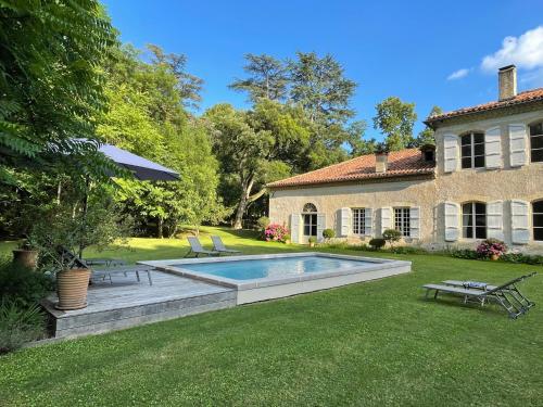 une cour arrière avec une piscine et une maison dans l'établissement Maison Gascony, à LʼIsle-de-Noé