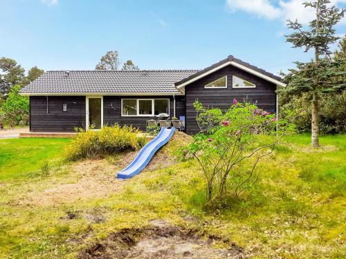 um escorrega azul em frente a uma casa em 8 person holiday home in Hadsund em Hadsund