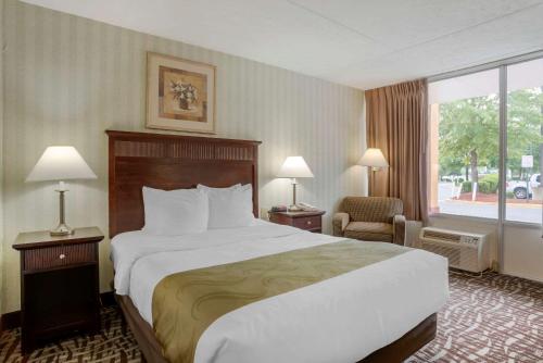 a hotel room with a large bed and a window at Quality Inn Fredericksburg near Historic Downtown in Fredericksburg