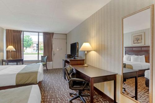 a hotel room with two beds and a desk at Quality Inn Fredericksburg near Historic Downtown in Fredericksburg