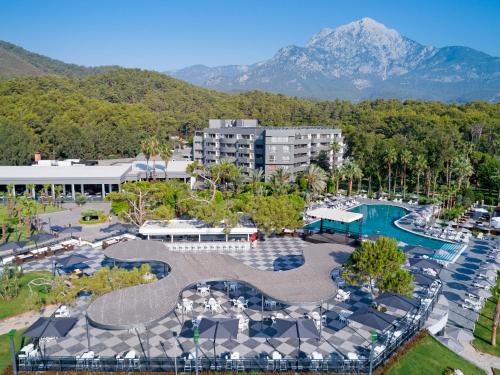 an aerial view of a resort with a mountain in the background at Mövenpick Resort Antalya Tekirova - Ultra All Inclusive in Tekirova