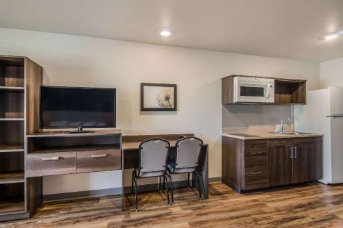 a kitchen with two chairs and a desk with a microwave at WoodSpring Suites Broomfield-Westminster in Broomfield