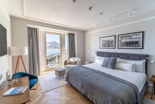 1 dormitorio con cama grande y ventana grande en Lasala Plaza Hotel en San Sebastián