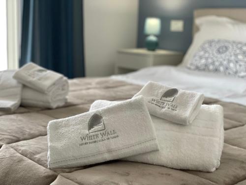 two towels sitting on top of a bed at White Wall luxury rooms Scala dei turchi in Realmonte