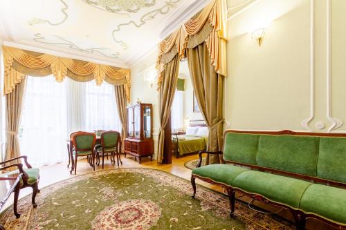 a living room with a green couch and chairs at Bristol Zhiguly Hotel in Samara