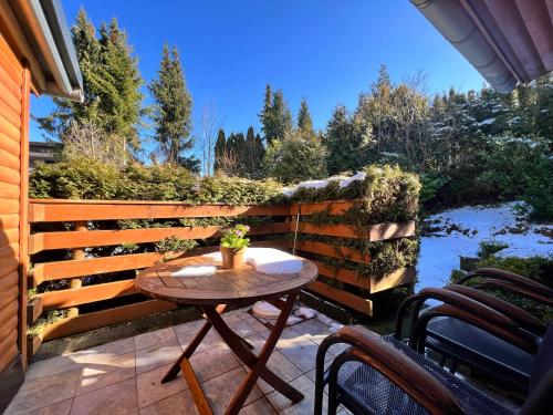 eine Terrasse mit einem Tisch und Stühlen neben einem Zaun in der Unterkunft Das kleine Klee in Hahnenklee-Bockswiese