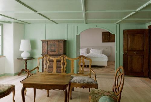 Zimmer mit einem Tisch, Stühlen und einem Bett in der Unterkunft Gasthof Hirschen in Eglisau