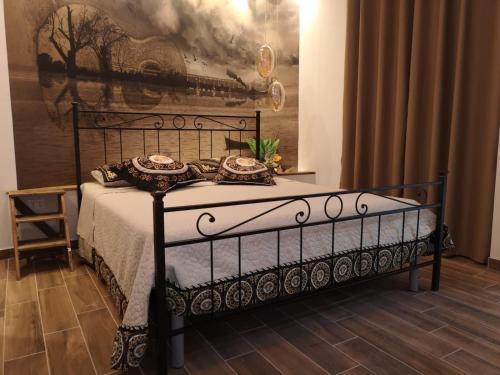 a black bed in a room with a painting on the wall at Le 3 Dee in Reggio Calabria