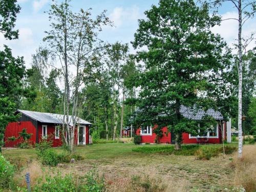 a red house in the middle of a forest at 4 person holiday home in VITTSJ in Vittsjö