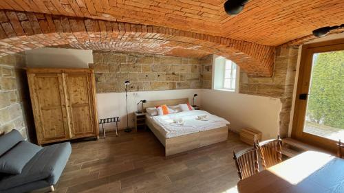 een slaapkamer met een bed in een bakstenen muur bij Penzion Pod Devítkou in Hřensko