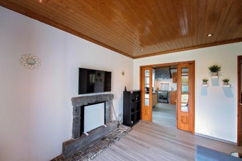 sala de estar con chimenea y techo de madera en Garden Oasis en Capelo
