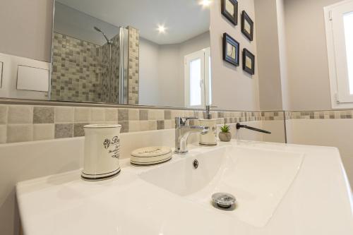 a white bathroom with a sink and a mirror at PÌSO MAR ALTEA in Altea