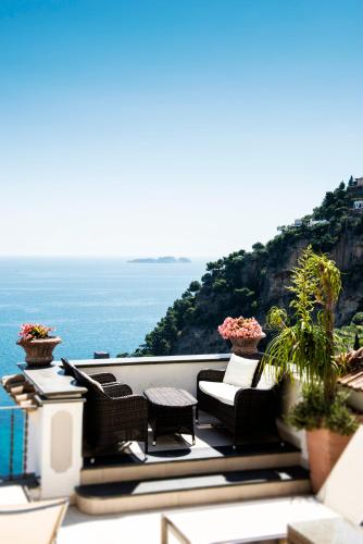a balcony with chairs and a view of the ocean at Hotel Punta Regina in Positano