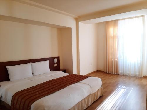 a bedroom with a large bed and a large window at Park Resort Aghveran in Aghveran