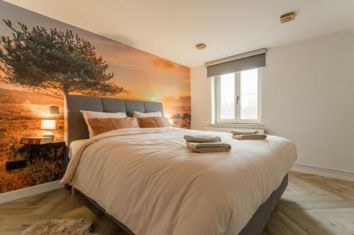 a bedroom with a large bed with a painting on the wall at De Dommelhoeve in Peer