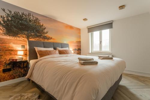 a bedroom with a large bed with a painting on the wall at De Dommelhoeve in Peer