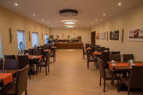 a dining room with tables and chairs and a courtroom at Zur Morschbach in Altlay