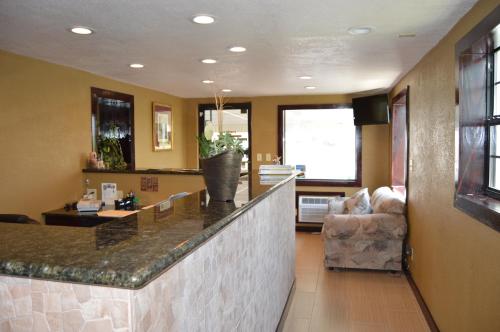 a kitchen with a counter and a living room at Travel Inn Weatherford in Weatherford