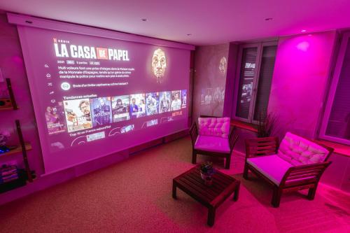 a room with two chairs and a screen with purple lights at La Suite d'Aubière in Aubière