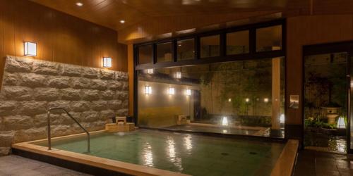 Una gran piscina en un edificio con un gran ventanal. en Nishitetsu Resort Inn Beppu, en Beppu