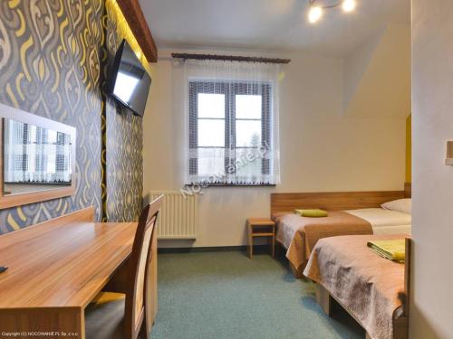 Ένα ή περισσότερα κρεβάτια σε δωμάτιο στο Zajazd Pod Caryńską