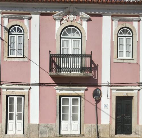 a pink and white building with a balcony at Casa da Mité in Cercal