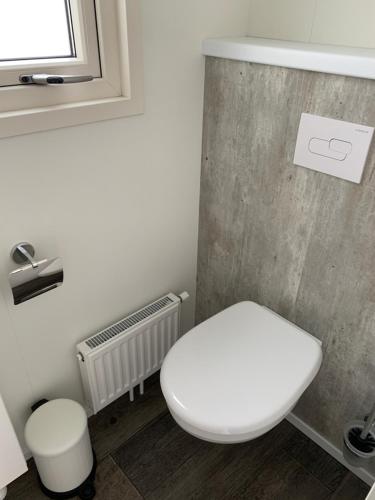 a bathroom with a white toilet and a window at Chalet (A16) op gezellige familiecamping bij zee in Kamperland