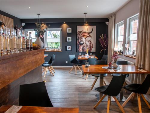 a bar with tables and chairs in a room at KOCHWERK Restaurant & Pension in Zingst