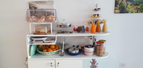 a white shelf with fruits and other items on it at Le Perle d'Italia in Ravello