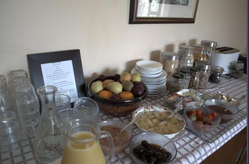 una mesa cubierta con tazones de fruta y otros alimentos en Old Orchard Lodge B&B, en Rosslare