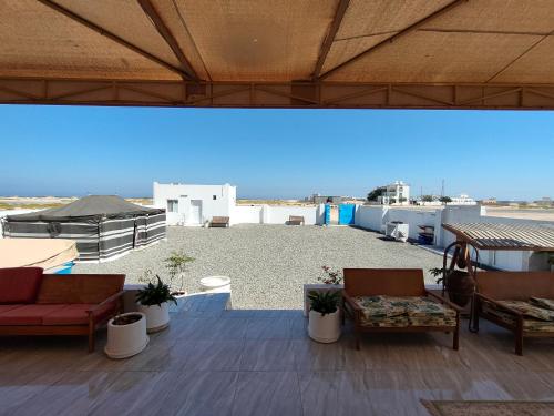 Un patio con sillas y mesas en un tejado. en Ras Al Hadd Orchid, en Al Hadd