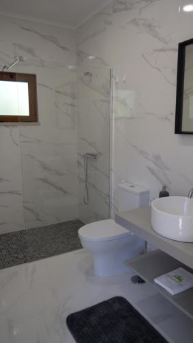 a white bathroom with a toilet and a sink at Casa Rosa, Quinta Carmo - Alcobaça/Nazaré in Alcobaça