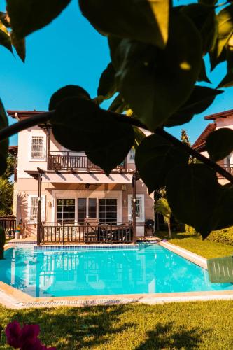 a swimming pool in front of a house at Aysimi Villas in Kemer
