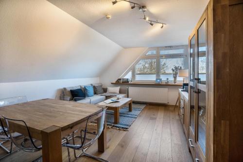 uma sala de estar com uma mesa e um sofá em Ferienwohnung Uttied em Baltrum