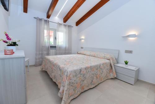 a white bedroom with a bed and a window at La dimora di Venere in Agerola