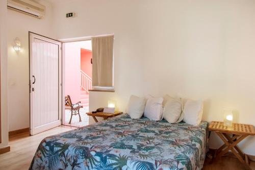 a bedroom with a bed with pillows and a table at Casa Viana - Guesthouse in Cabanas de Tavira