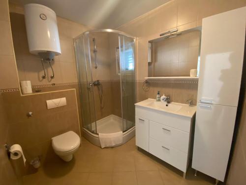 スリマにあるLucich Apartments Srimaのシャワー、トイレ、洗面台を備えたバスルーム