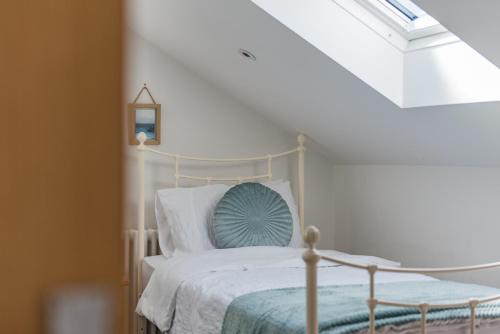 a bedroom with a white bed with a blue pillow at The George - Large family home by the sea in Deal