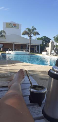 a person sitting on a towel next to a swimming pool at Apart Hotel Iken in Federación