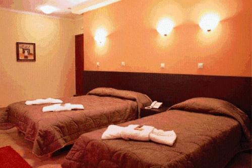 two beds in a hotel room with towels on them at Asteras Hotel in Naousa Imathias