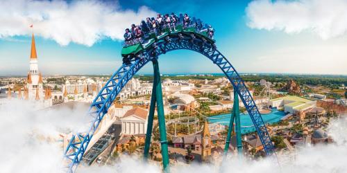 a roller coaster in front of a city at The Land Of Legends Kingdom Hotel - All-in Concept in Belek