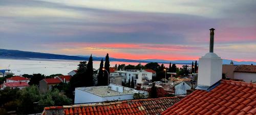 Blick auf eine Stadt bei Sonnenuntergang mit einer Kirche in der Unterkunft Holiday Home Sea Beach Dvorska 37 in Crikvenica