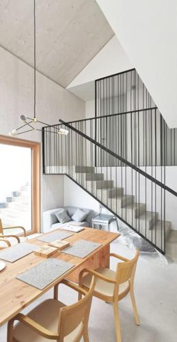 a dining room with a table and chairs and a staircase at Urban Mountain Splitlevel with Lake View in Maurach