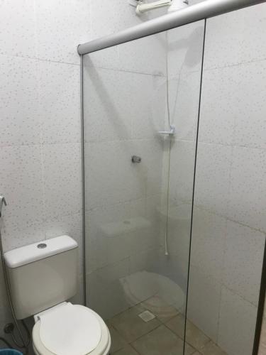ein Badezimmer mit Toilette und Glasdusche in der Unterkunft Suites em Maresias in Maresias