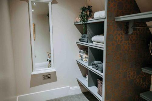 a walk in closet with a mirror and towels at Apartment22. A stylish and spacious Apartment in the heart of Historic Market town of Beverley. in Beverley