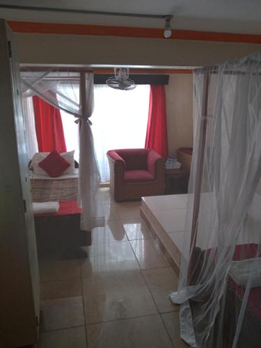 a room with a bed and a couch and a window at Ocean View Nyali Boutique Hotel in Nyali