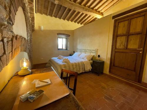 um quarto com uma cama e uma mesa num quarto em Porta del Chianti Tuscany Apartment em San Casciano in Val di Pesa