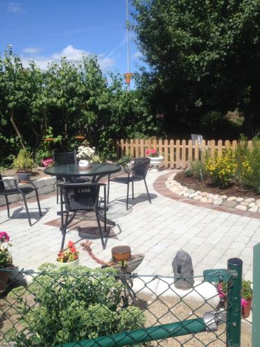 a patio with a table and chairs in a garden at Vivans Bed and Self catering in Kristianstad