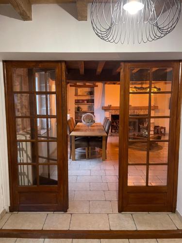 ein Esszimmer mit Glastüren und einem Tisch in der Unterkunft Maison La Reine in La reine