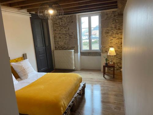 a bedroom with a yellow bed and a window at Maison La Reine in La reine